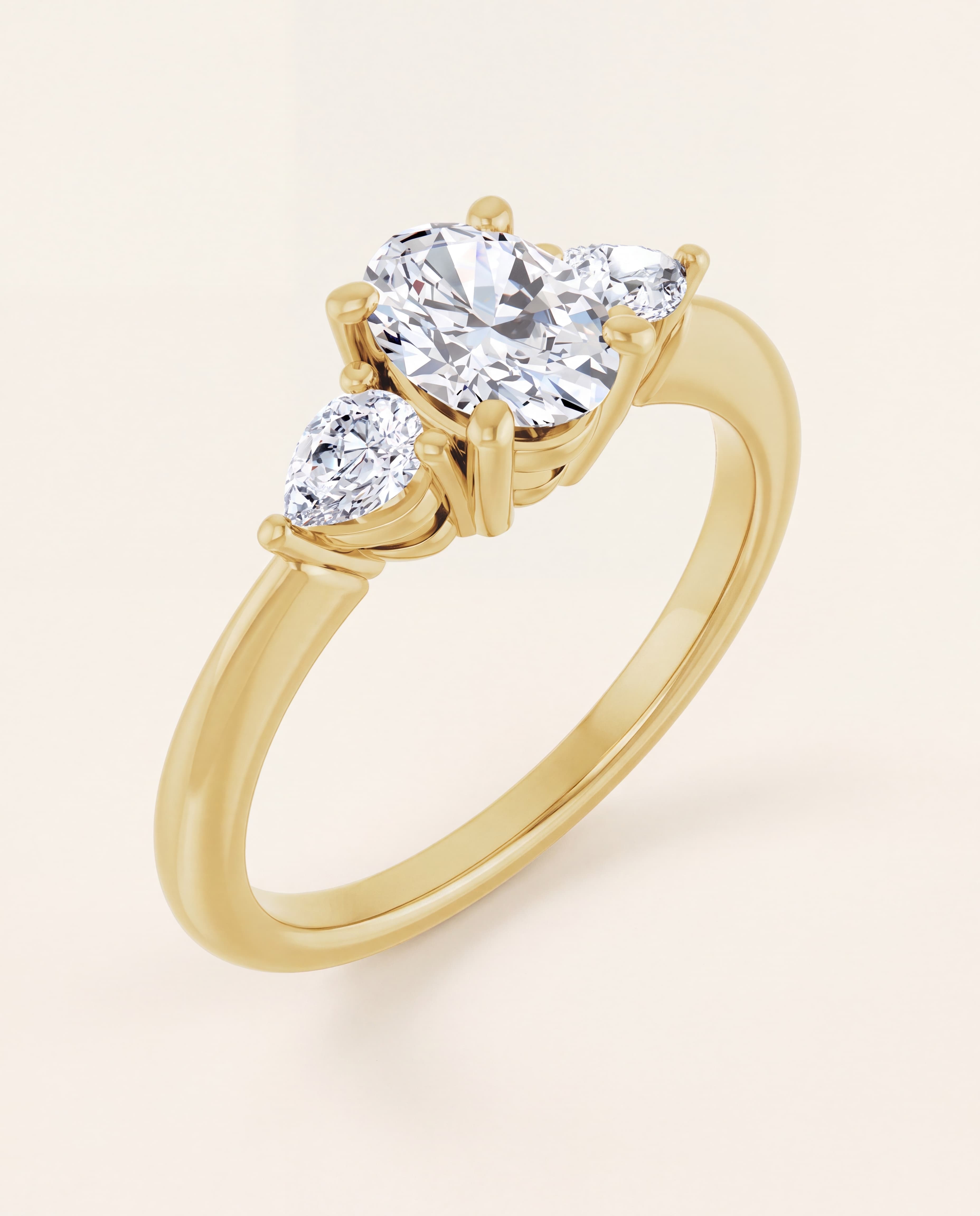 Oval and Pear Three Stone Engagement Ring in yellow gold