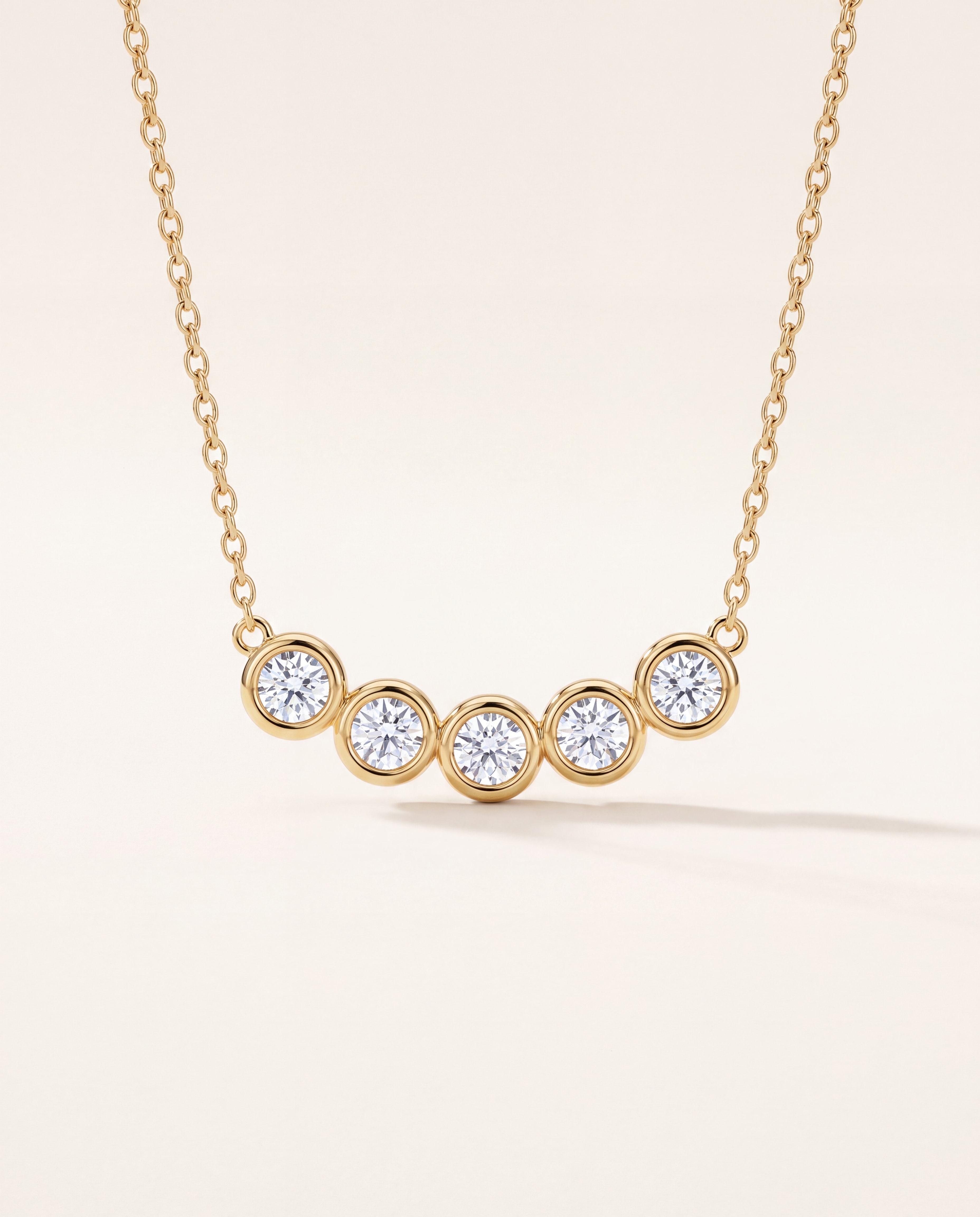 Five Station Bezel Necklace in 14K yellow gold, studio photo on ivory